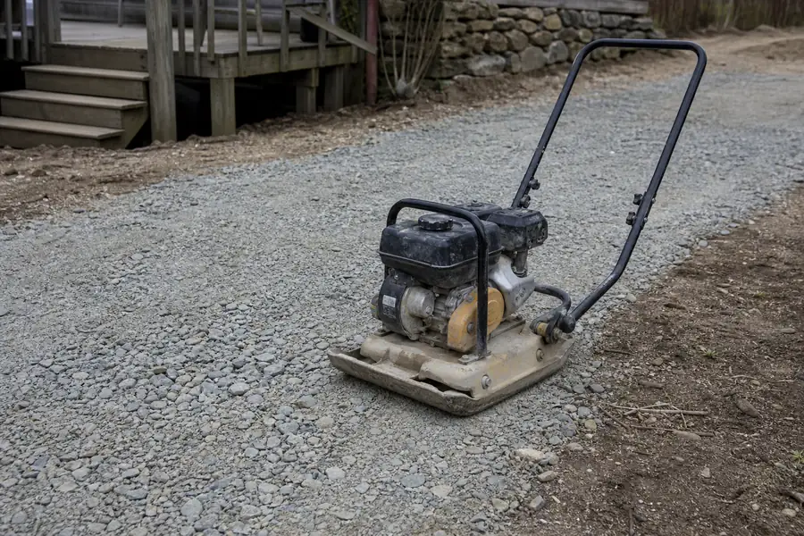 Plate compactor on a crusher run driveway base