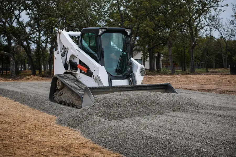 Skid steer spreading flex base for a new driveway in Texas