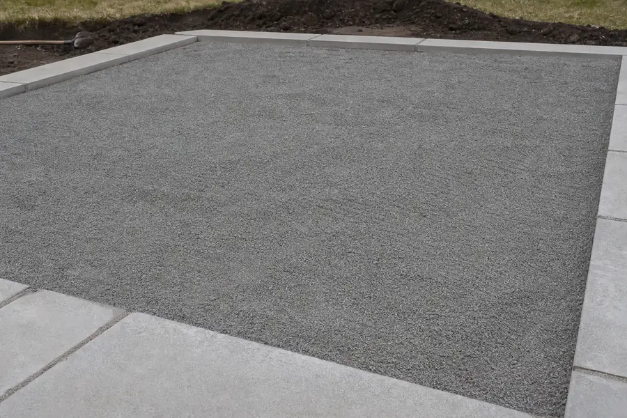 Fine grey limestone screenings raked level as a paver bed