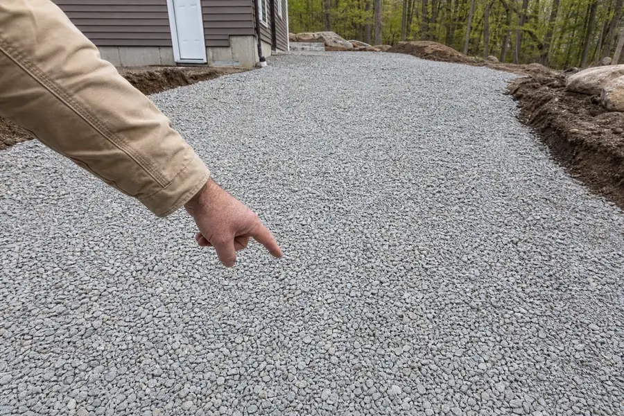 Contractor pointing at a spread of 3/4 inch crushed limestone on a new driveway