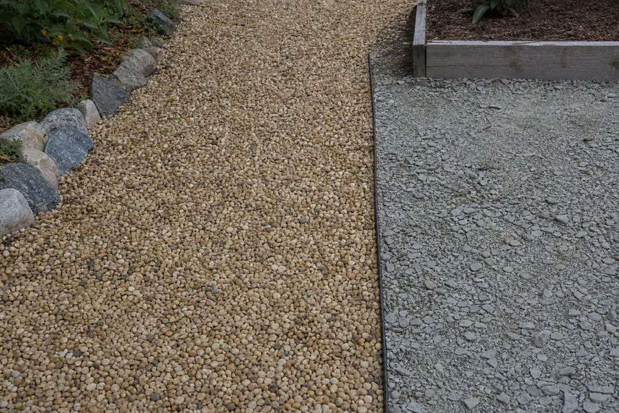 Garden path finished with pea gravel beside a crushed stone base sample